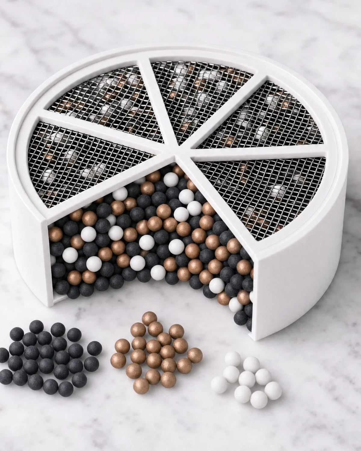 The Bath Ball disk cartridge cut open to show carbon, copper ERA and white ceramic spheres under its stainless steel mesh face