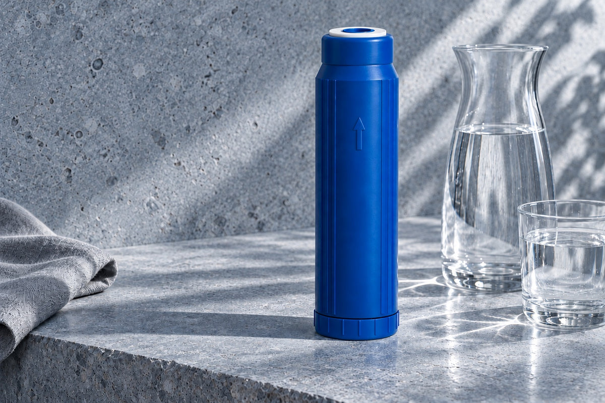 SMART cartridge on a blue-grey stone ledge beside a glass carafe of water, cool morning light