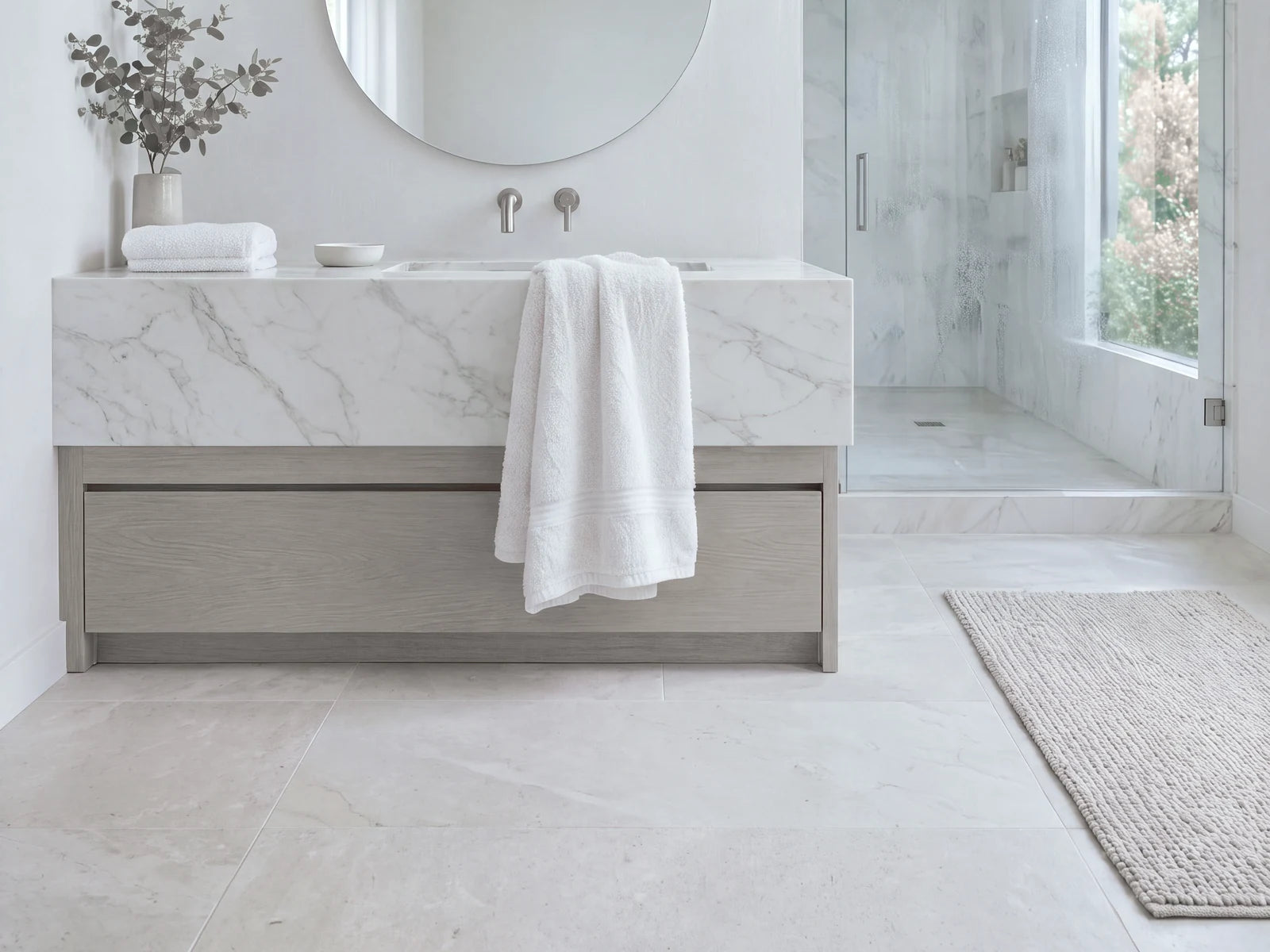 A soft white towel beside a glass shower