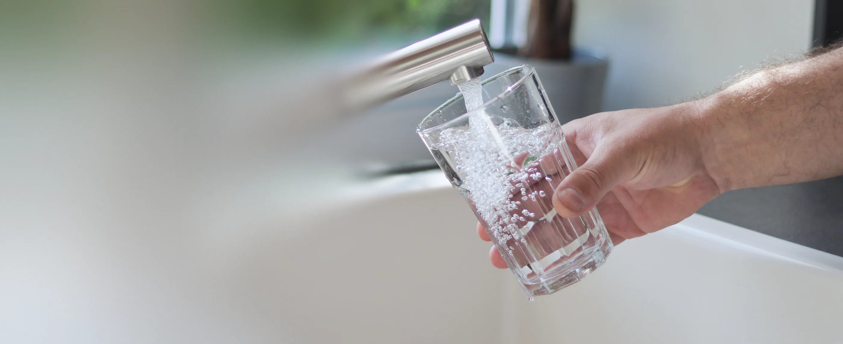 A glass being filled with water at a kitchen tap