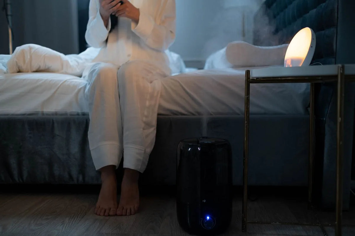 Cool mist humidifier running beside a bed in a home bedroom