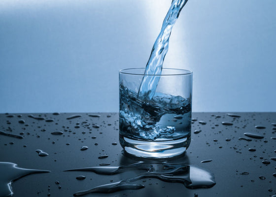 Clean filtered water being poured into a clear drinking glass