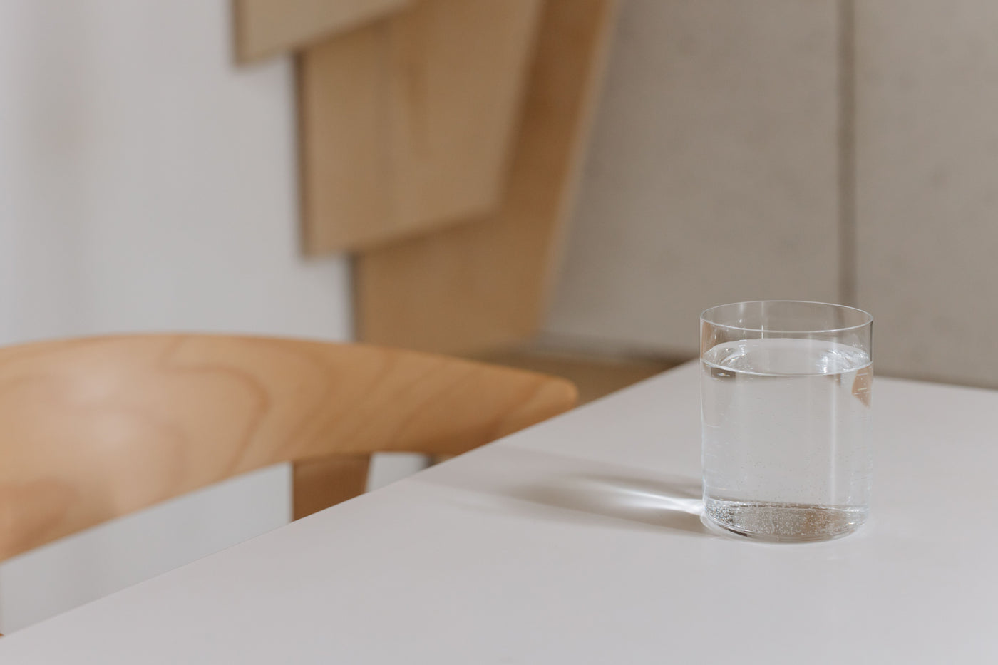 Clear glass of drinking water on a bright kitchen table at home