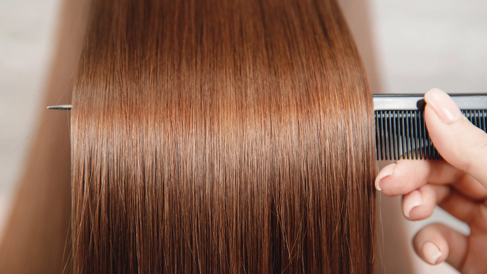 Person using a comb on copper dyed hair