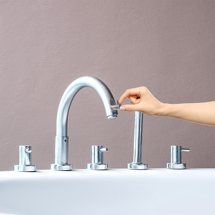 Bath Ball Hook being attached to a chrome bathtub spout by hand