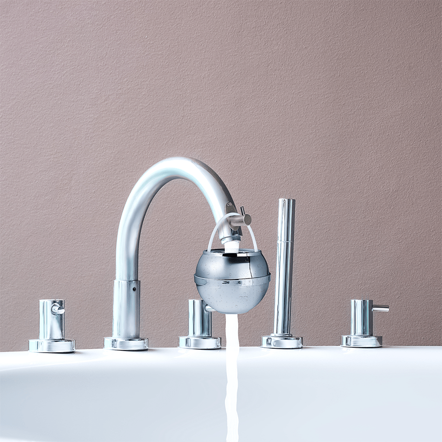 Bath Ball hanging from the Bath Ball Hook on a bathtub spout with water flowing through