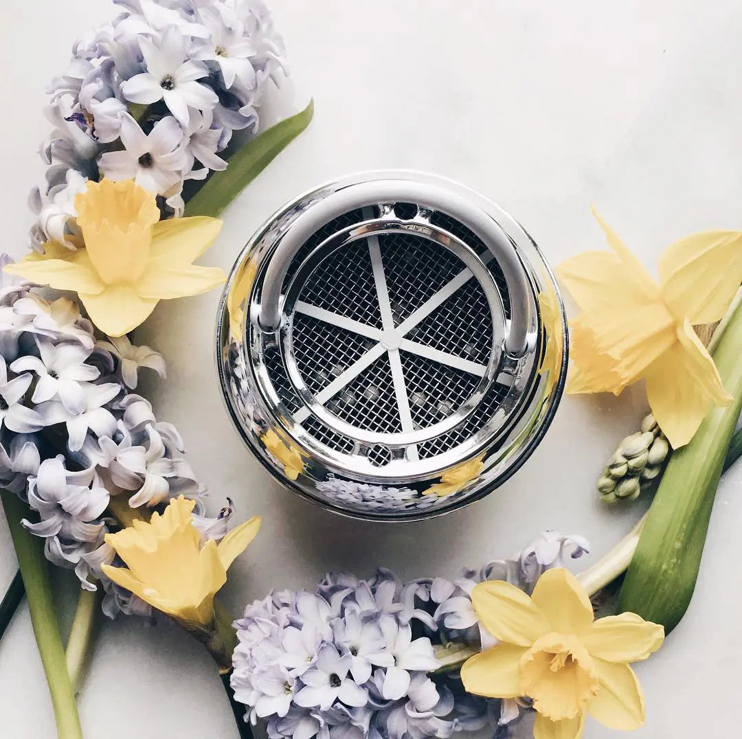 bath ball filter on display surrounded by flowers on a white background