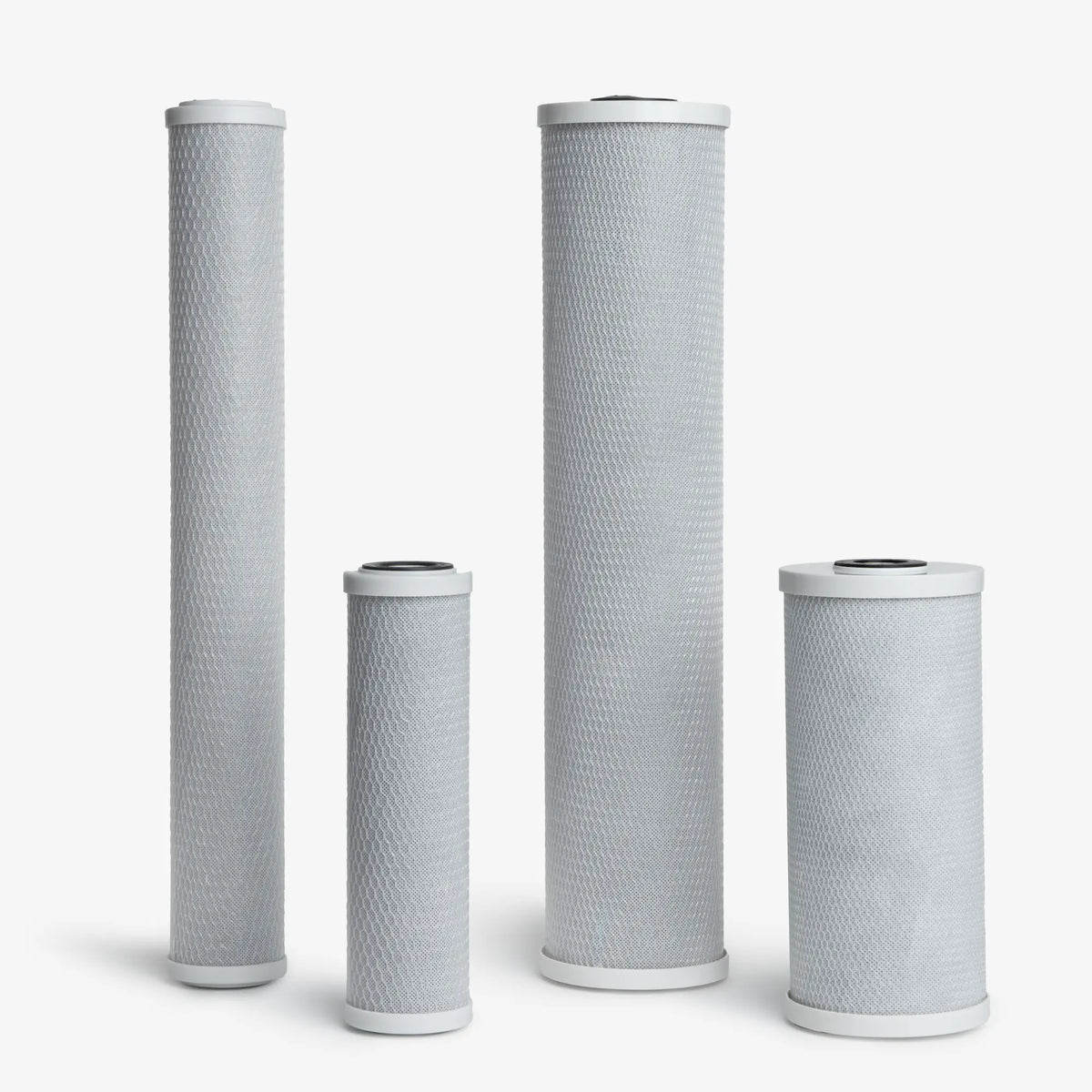 Coconut Based 5-Micron Carbon Block Filter Cartridge in four sizes, gray mesh-wrapped blocks with white end caps
