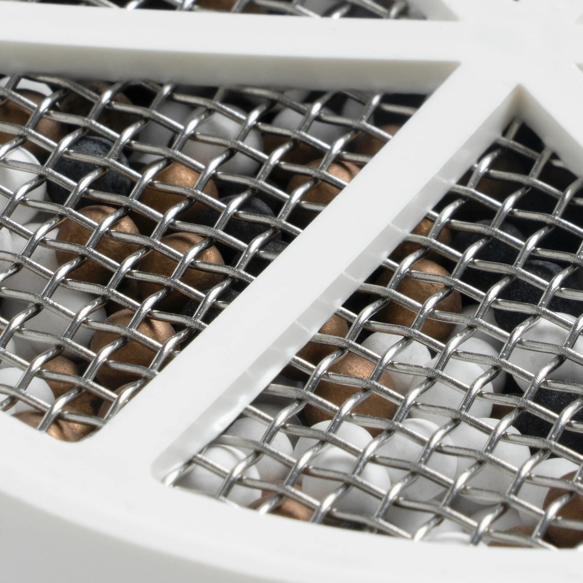 Close-up of the cartridge's woven stainless steel mesh with media spheres behind it