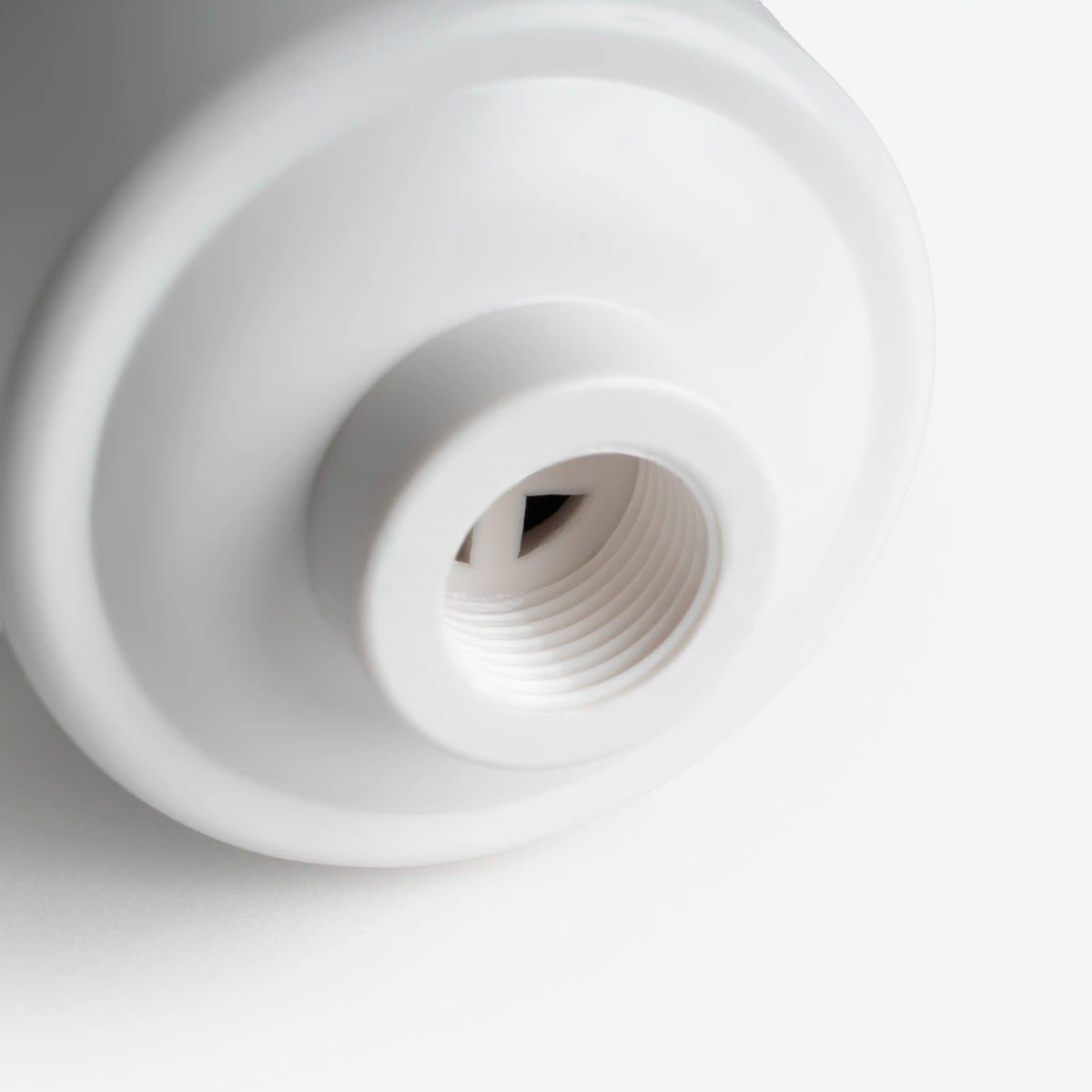 Shower Filter, close-up of the threaded opening on the bottom of the white housing