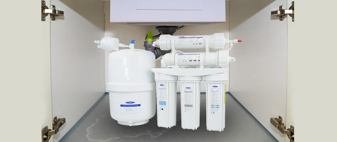Water filtration system installed in a kitchen cabinet.