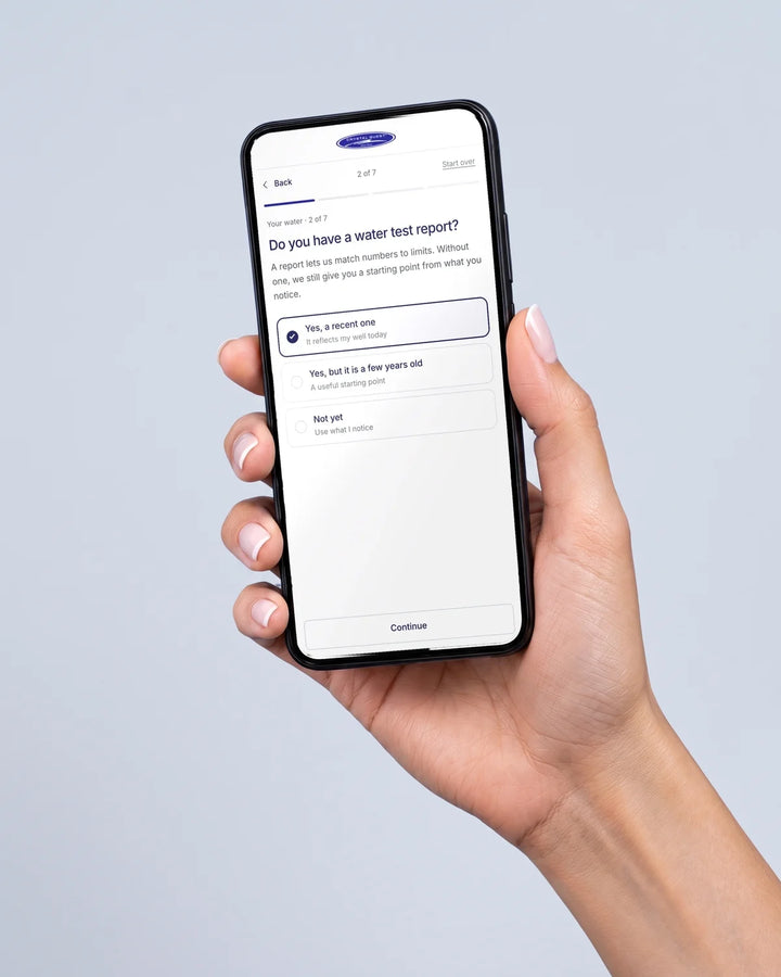 A hand holding a phone showing the Crystal Quest quiz