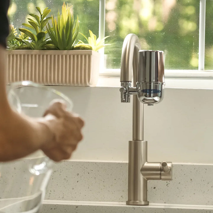 Filling a glass pitcher at a kitchen tap